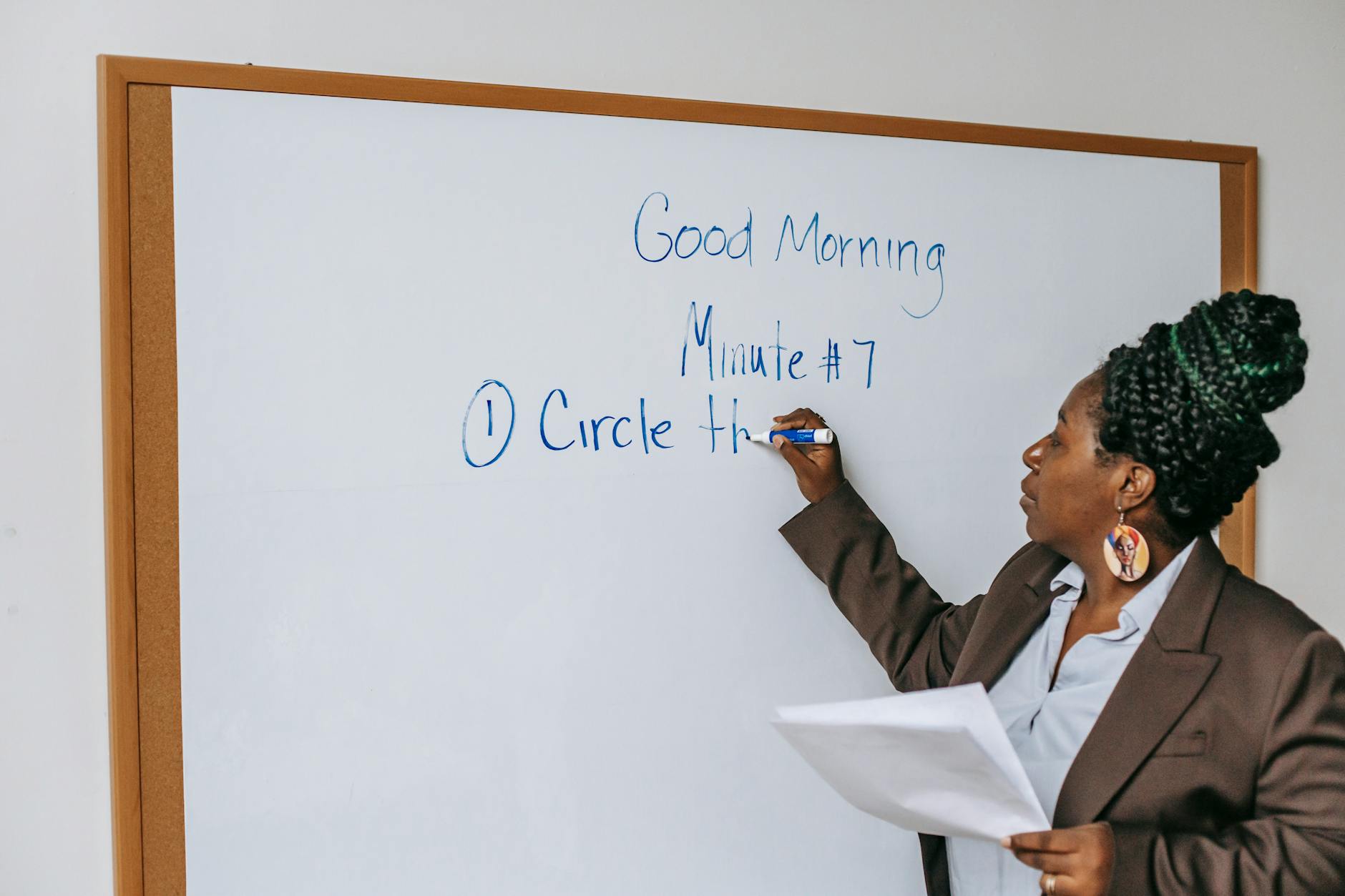 Black female teacher writing on whiteboard