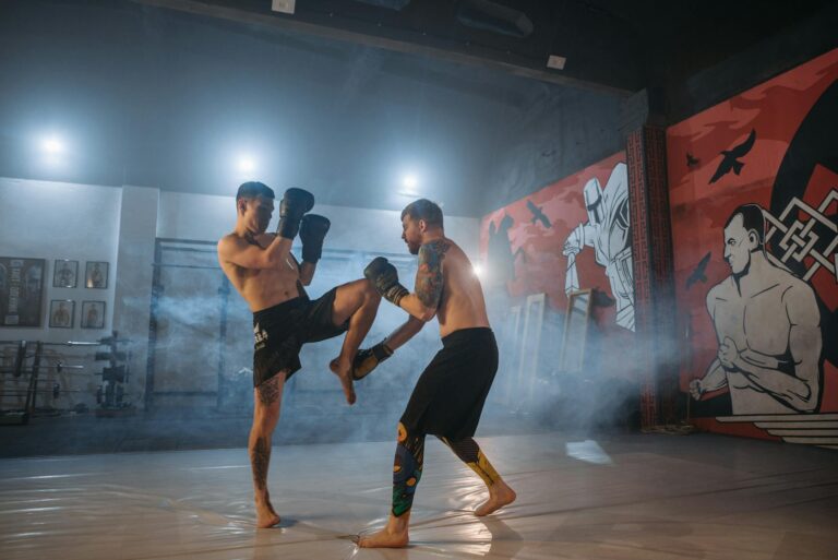 Two athletes engaged in an intense MMA sparring session inside a gym with striking wall art.